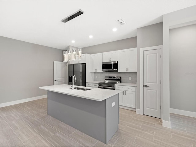 24520 Kingsway Cir, Punta Gorda, FL 33983 - kitchen featuring visible vents, backsplash, appliances with stainless steel finishes, a kitchen island with sink, and a sink