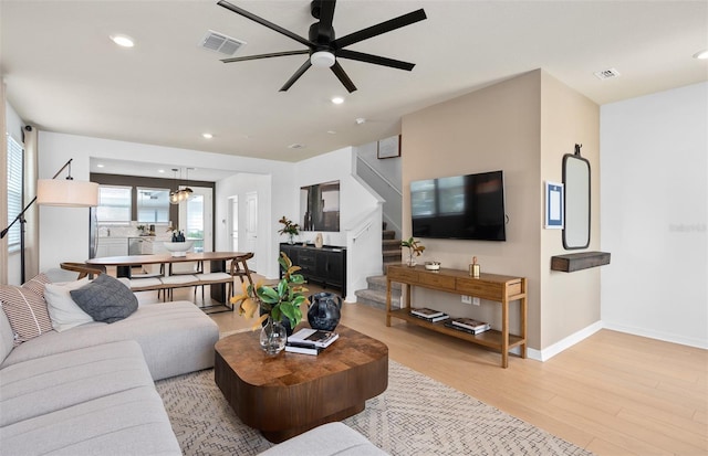 living area featuring stairway, recessed lighting, visible vents, and light wood-style floors