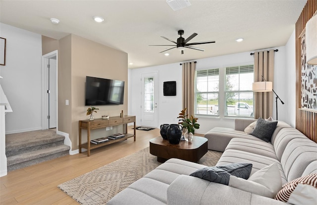 living room with baseboards, light wood-style flooring, visible vents, and recessed lighting