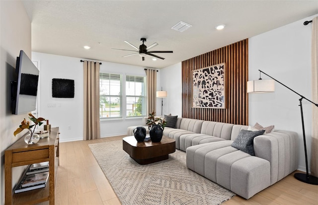 living room with recessed lighting, visible vents, light wood-style floors, ceiling fan, and baseboards