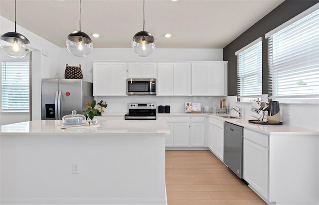 kitchen with white cabinetry, decorative backsplash, stainless steel appliances, and a sink