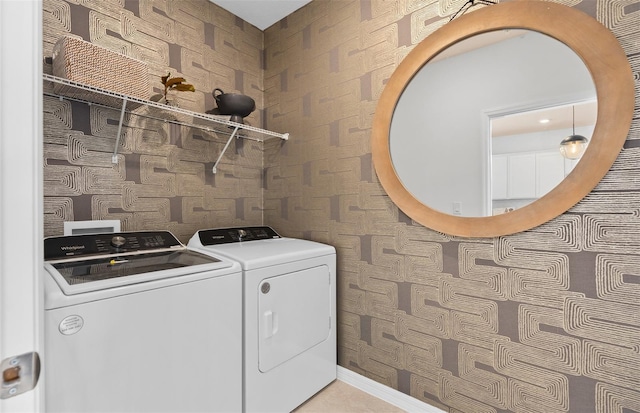 laundry room with laundry area, washing machine and dryer, and wallpapered walls