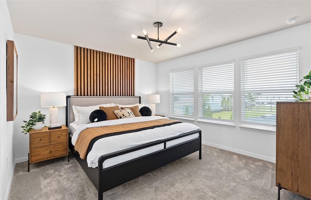 bedroom featuring a notable chandelier, carpet floors, and baseboards