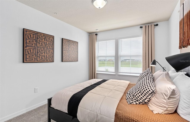 carpeted bedroom with a textured ceiling and baseboards