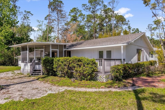 view of front of property with a front yard and a sunroom