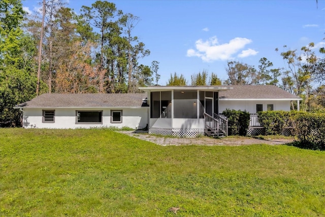 back of property with a yard and a sunroom