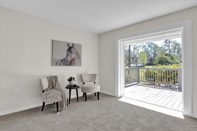 living area with baseboards and carpet