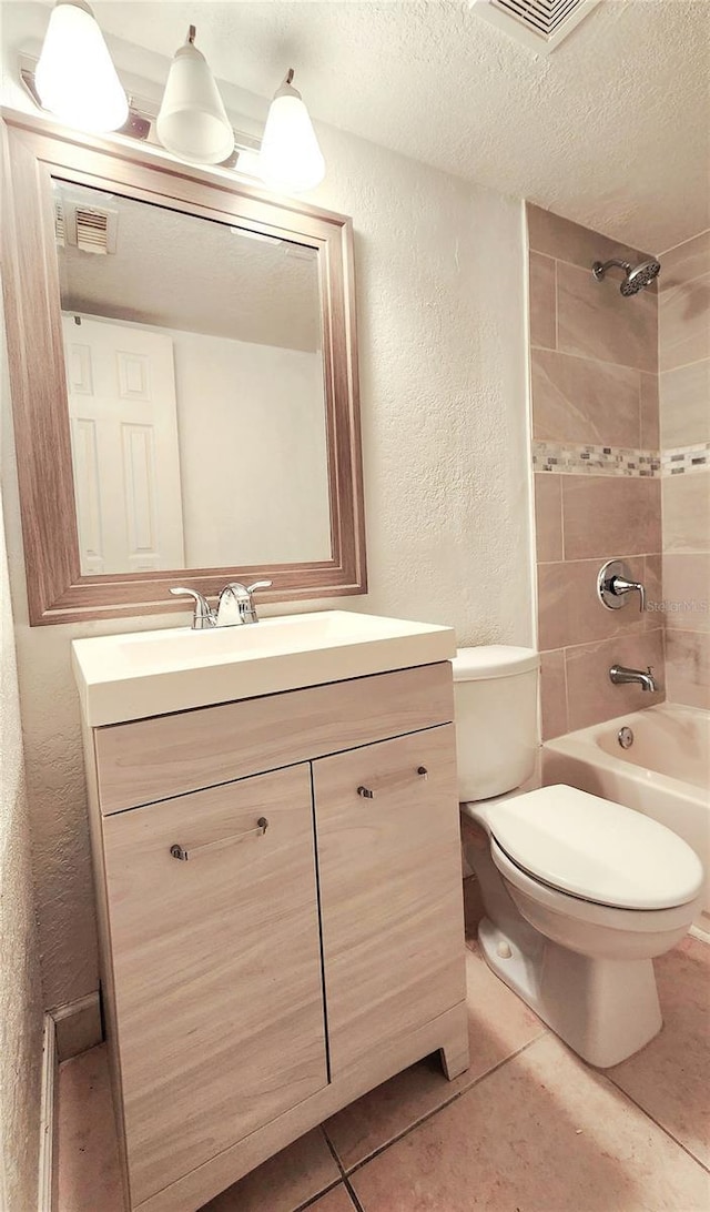 full bathroom featuring a textured wall, toilet, tile patterned flooring, a textured ceiling, and vanity