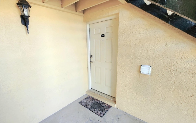 doorway to property featuring stucco siding