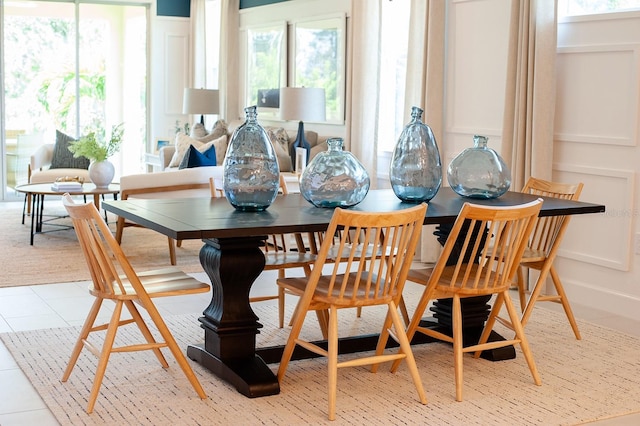 dining area featuring light tile patterned floors and a decorative wall