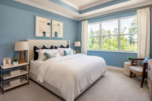 bedroom with carpet floors, baseboards, ornamental molding, and a raised ceiling