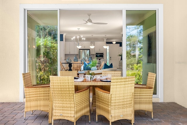 dining space with ceiling fan, brick floor, and crown molding