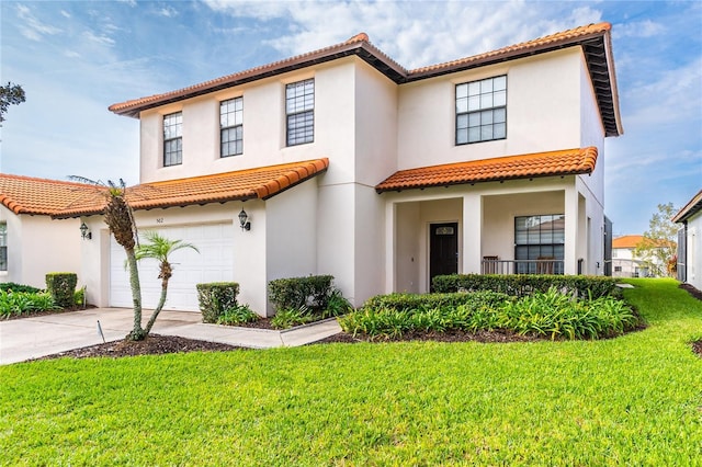 mediterranean / spanish house featuring a garage, a front yard, driveway, and stucco siding