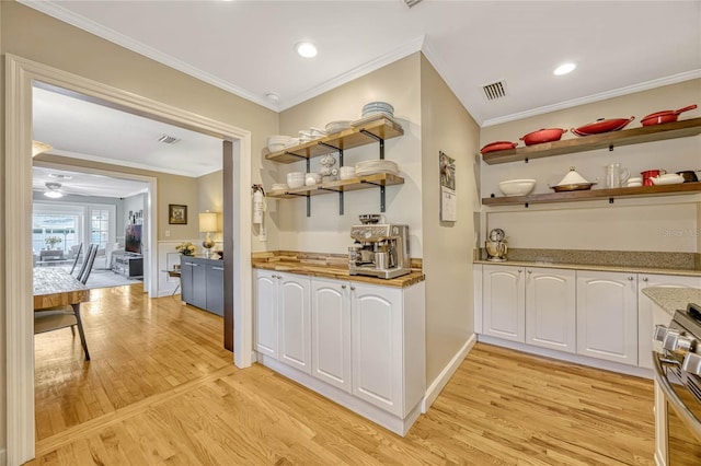 bar with crown molding, stainless steel range, visible vents, and light wood-style floors