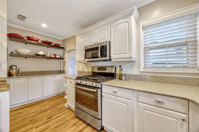 kitchen with visible vents, white cabinets, ornamental molding, appliances with stainless steel finishes, and light wood-type flooring