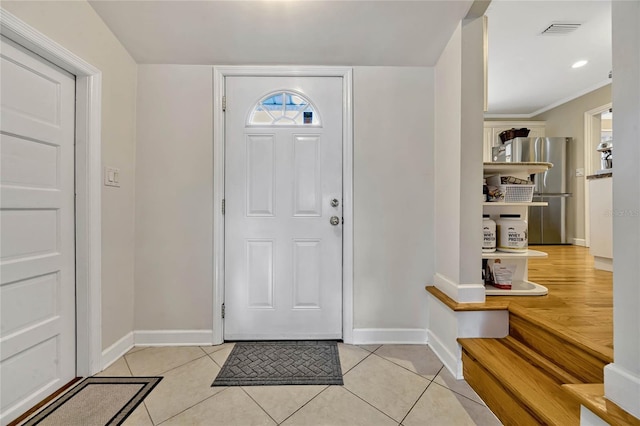 foyer featuring light tile patterned flooring, visible vents, and baseboards