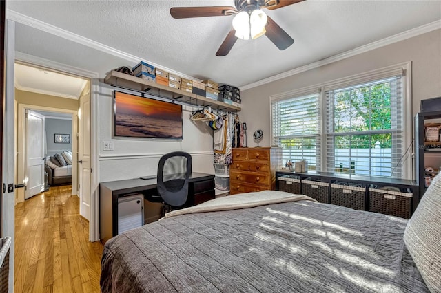 bedroom with a ceiling fan, crown molding, a textured ceiling, and wood finished floors