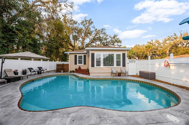 view of pool with a fenced in pool, a fenced backyard, a patio, and an outdoor structure