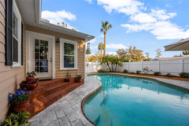 view of swimming pool featuring a fenced in pool, a fenced backyard, and a patio