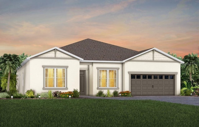 view of front of house featuring a garage, roof with shingles, decorative driveway, a front yard, and stucco siding