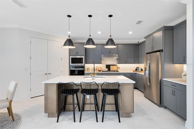 kitchen with visible vents, appliances with stainless steel finishes, a kitchen island with sink, under cabinet range hood, and a sink