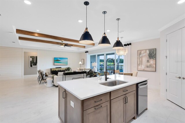 kitchen featuring a raised ceiling, ornamental molding, a sink, light countertops, and stainless steel dishwasher