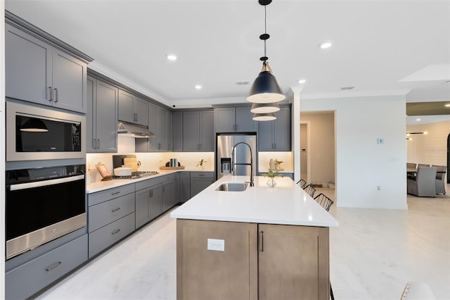 kitchen featuring crown molding, light countertops, appliances with stainless steel finishes, a sink, and under cabinet range hood