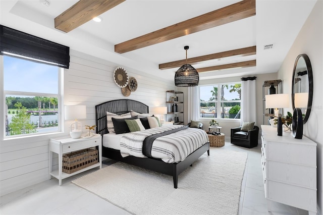 bedroom with beam ceiling, visible vents, and wooden walls