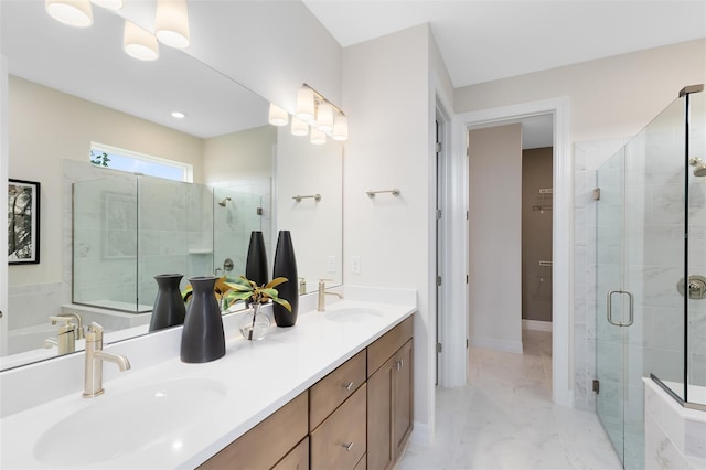 bathroom featuring marble finish floor, a sink, a shower stall, and double vanity