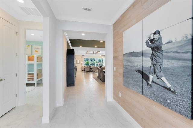 hall with ornamental molding, marble finish floor, and visible vents