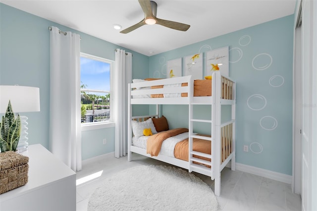 bedroom with ceiling fan and baseboards