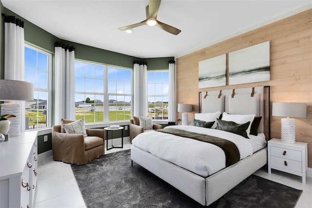 bedroom featuring wood walls and a ceiling fan