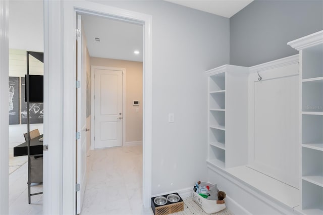 interior space featuring recessed lighting, marble finish floor, and baseboards