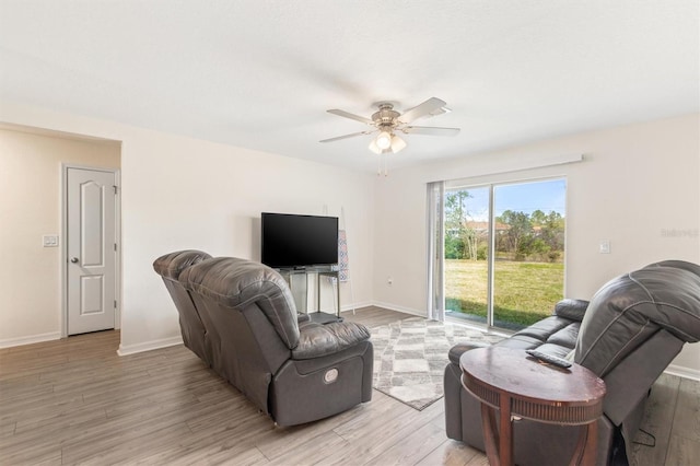 living room featuring light wood finished floors, ceiling fan, and baseboards