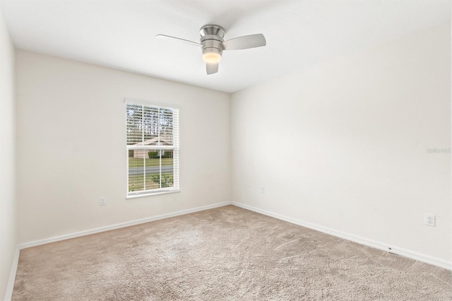 empty room featuring ceiling fan, baseboards, and carpet flooring