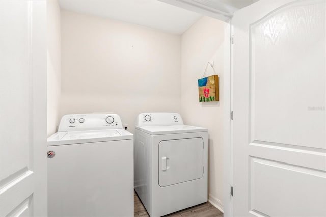 laundry room featuring laundry area, light wood finished floors, and washing machine and dryer