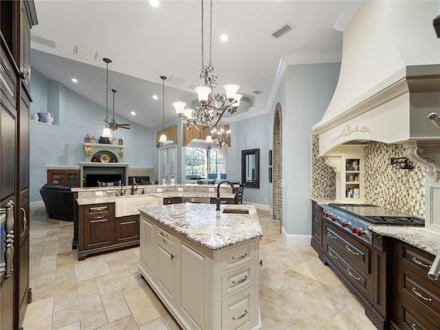 kitchen with visible vents, stainless steel gas stovetop, decorative backsplash, open floor plan, and a kitchen island with sink