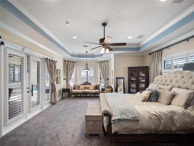 bedroom with a textured ceiling, carpet flooring, access to exterior, ornamental molding, and a tray ceiling