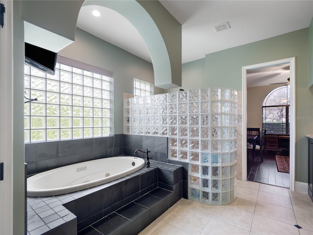 ensuite bathroom with tile patterned flooring, walk in shower, visible vents, a jetted tub, and ensuite bath