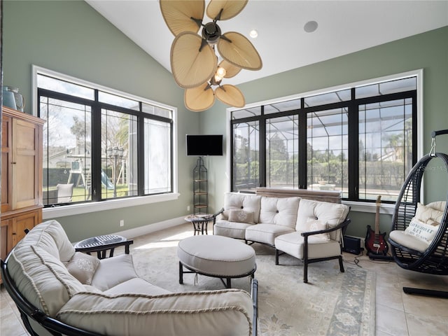 living room with vaulted ceiling, light tile patterned floors, a ceiling fan, and baseboards