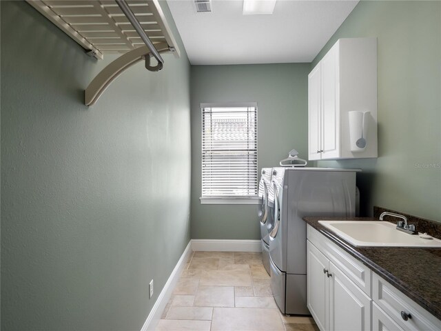 washroom featuring separate washer and dryer, a sink, visible vents, baseboards, and cabinet space