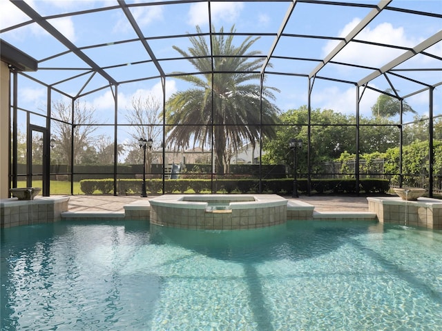 outdoor pool featuring an in ground hot tub, a patio area, and a lanai