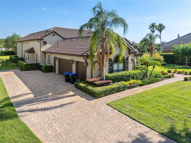 12860 Jacob Grace Ct, Windermere, FL 34786 - mediterranean / spanish home featuring an attached garage, decorative driveway, a front lawn, stucco siding, and a tile roof