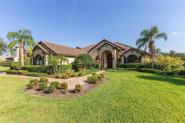 12860 Jacob Grace Ct, Windermere, FL 34786 - mediterranean / spanish-style home with stucco siding, a front lawn, and a tile roof