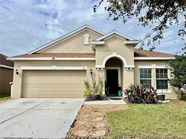 single story home featuring stucco siding, a shingled roof, a front yard, a garage, and driveway