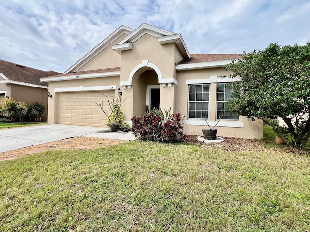 view of front of house with an attached garage, a front yard, concrete driveway, and stucco siding