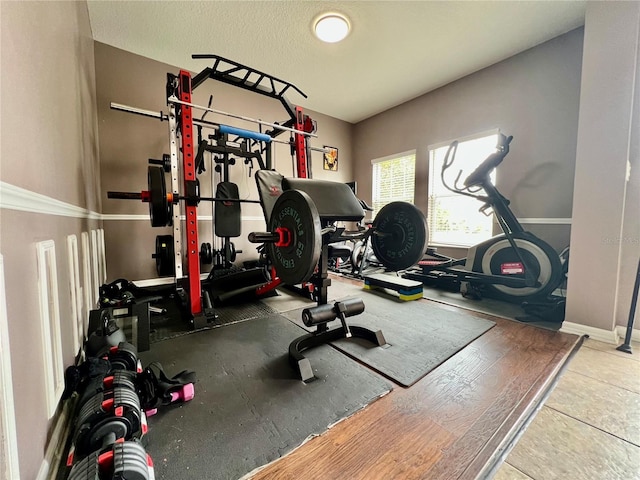 workout area featuring a textured ceiling and baseboards