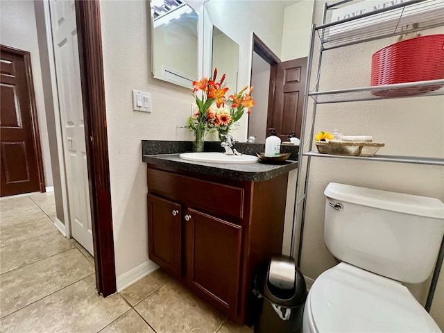 bathroom featuring tile patterned flooring, baseboards, vanity, and toilet