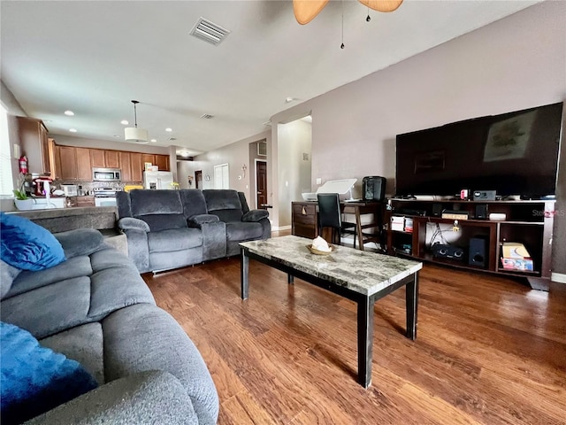 living area with recessed lighting, visible vents, baseboards, and wood finished floors