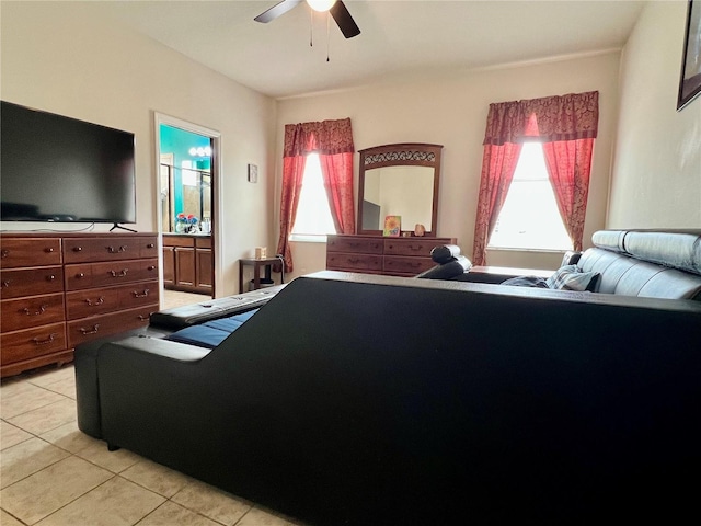 bedroom with light tile patterned flooring, connected bathroom, and a ceiling fan